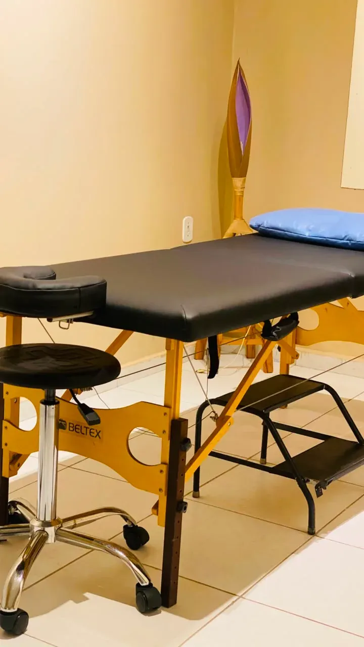Maca azul com apoio de cabeça e escada, em sala de fisioterapia.